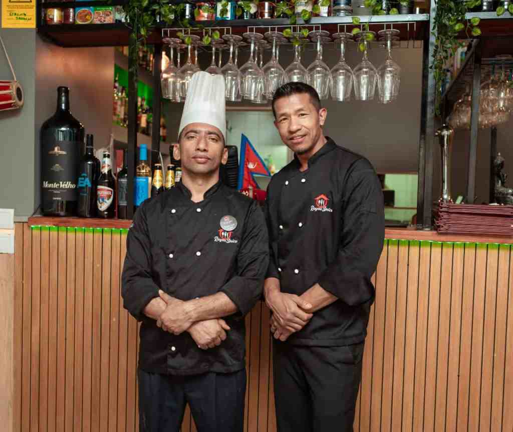 Main chef and sous chef at at Royal Spice Restaurant in Lisbon, standing in front of the restaurant bar.